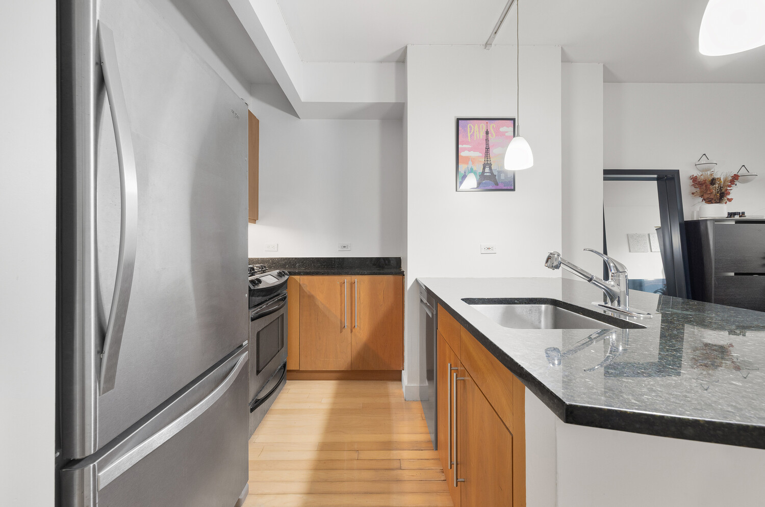 242 East 25th Street, Unit 7C Manhattan, NY 10010 - Photo 5 of 10 a kitchen with stainless steel appliances granite countertop a sink and a refrigerator