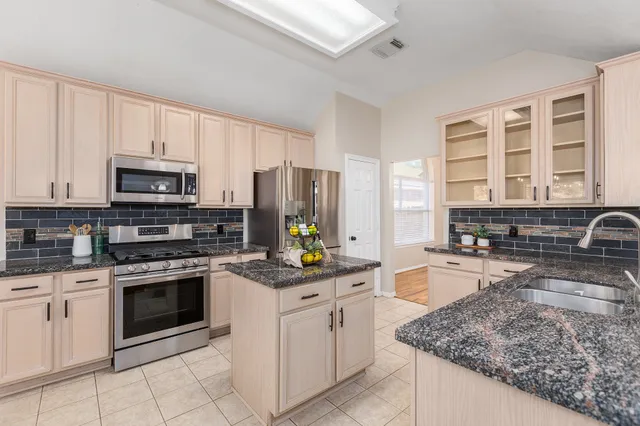 a kitchen with stainless steel appliances granite countertop a stove a sink and a microwave