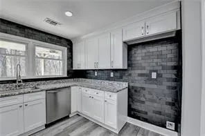 a kitchen with stainless steel appliances granite countertop a sink a stove and cabinets