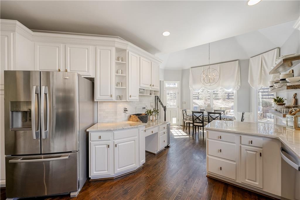14124 Hopewell Road Alpharetta, GA 30004 - Photo 5 of 31 a kitchen with white cabinets and stainless steel appliances