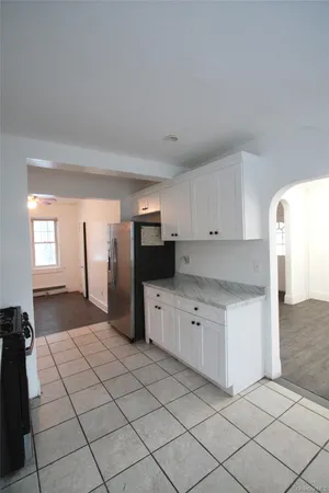 a kitchen with stainless steel appliances kitchen island granite countertop a refrigerator and a sink