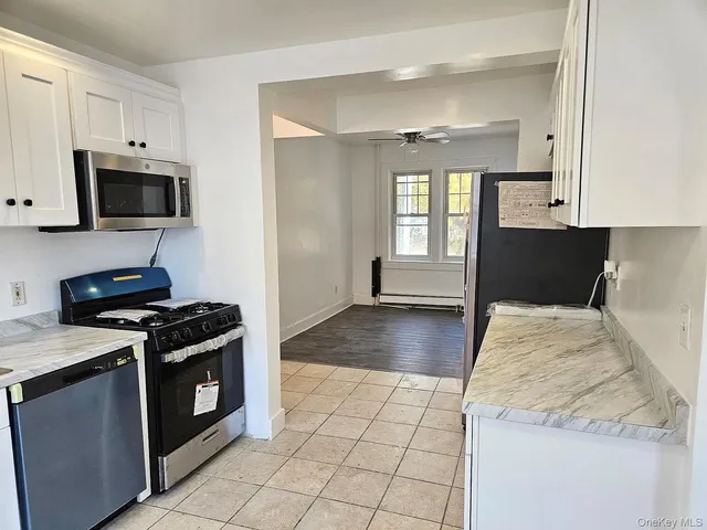 a kitchen with granite countertop a stove a sink and a microwave
