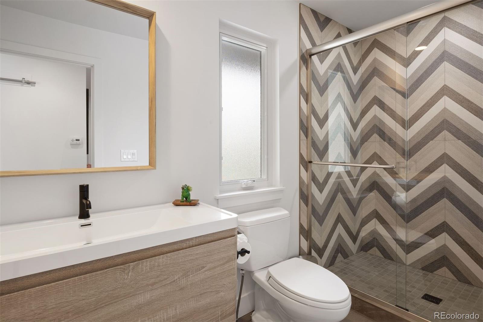 13380 Braun Road Golden, CO 80401 - Photo 17 of 49 a bathroom with a sink a mirror a toilet and a shower