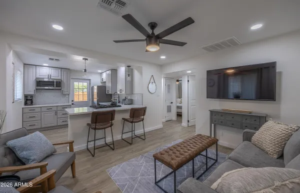 a living room with furniture kitchen view and a flat screen tv