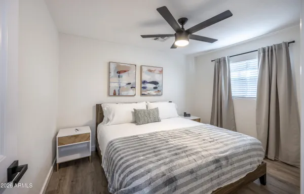 a bedroom with a bed and a ceiling fan