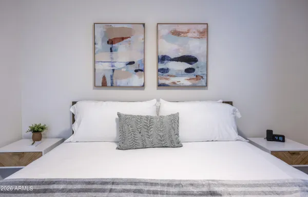 a bedroom with a large bed and a painting on the wall