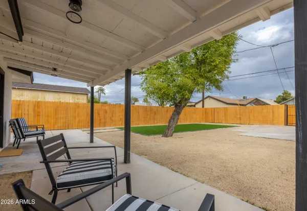 a view of a patio with a table and chairs under an umbrella