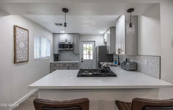 a kitchen with a appliances a sink and cabinets