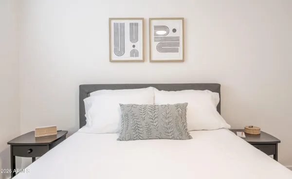 a bedroom with a bed and painting on the wall