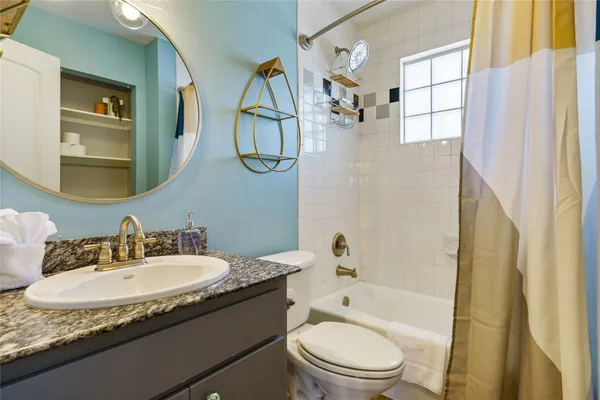 a bathroom with a granite countertop sink a toilet and shower