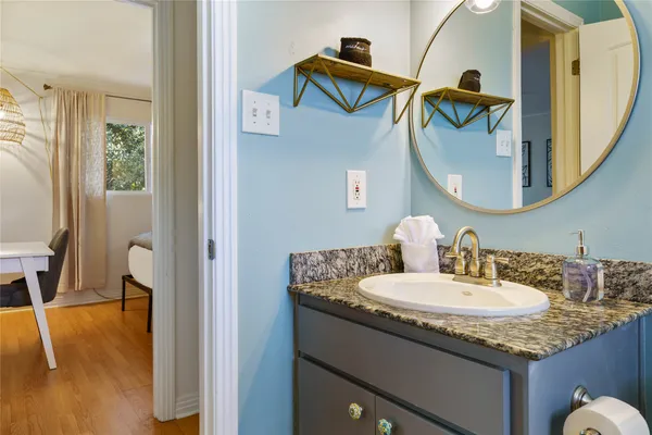 a bathroom with a granite countertop sink and a mirror