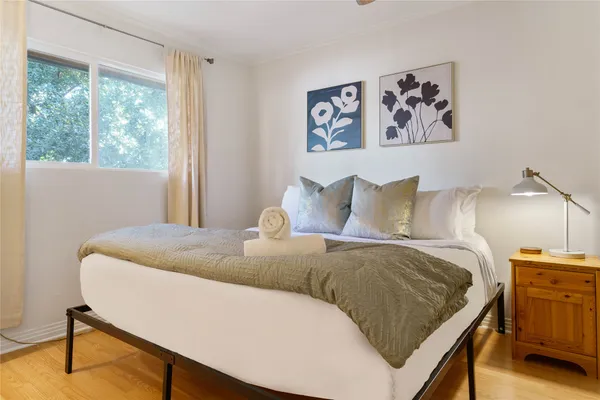 a bedroom with a bed and painting on the wall