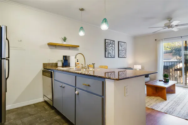 a kitchen with granite countertop a sink and a stove top oven