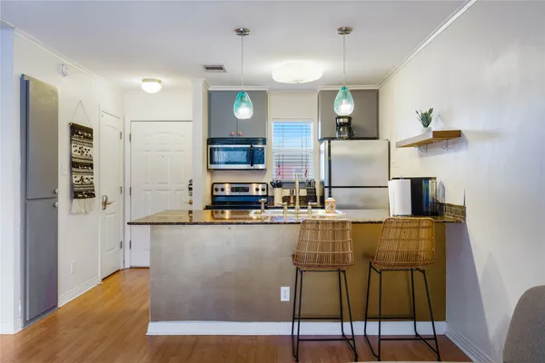 a kitchen with stainless steel appliances kitchen island granite countertop a refrigerator and microwave