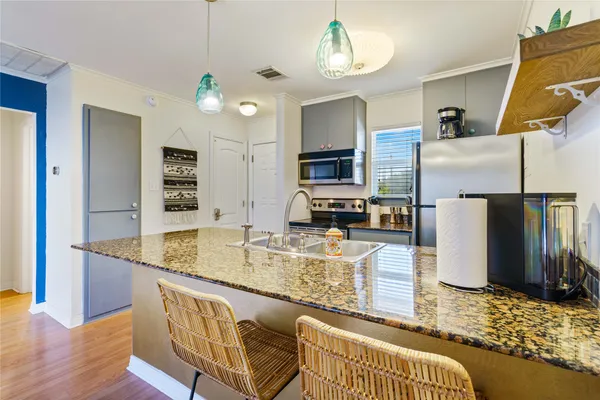 a kitchen with stainless steel appliances granite countertop a sink refrigerator and microwave