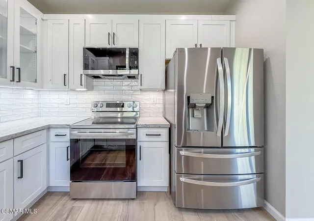 a kitchen with stainless steel appliances a refrigerator and a stove