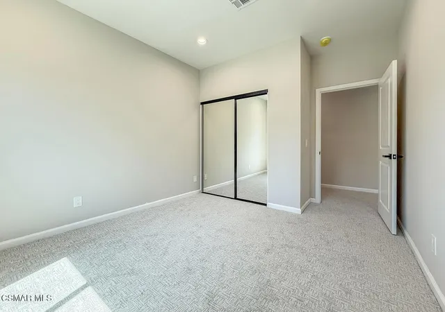 an empty room with closet and a bathroom view