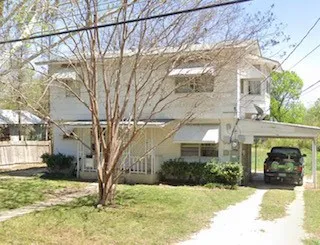 a view of a house with a yard covered in snow
