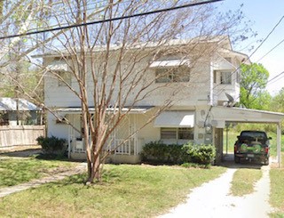 a view of a house with a yard covered in snow