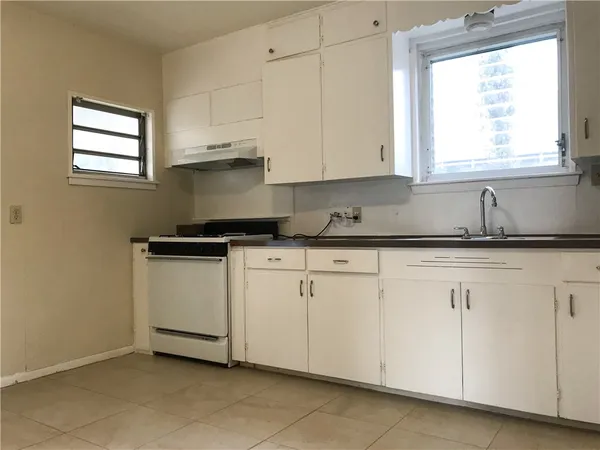 a kitchen with granite countertop white cabinets white appliances and a sink
