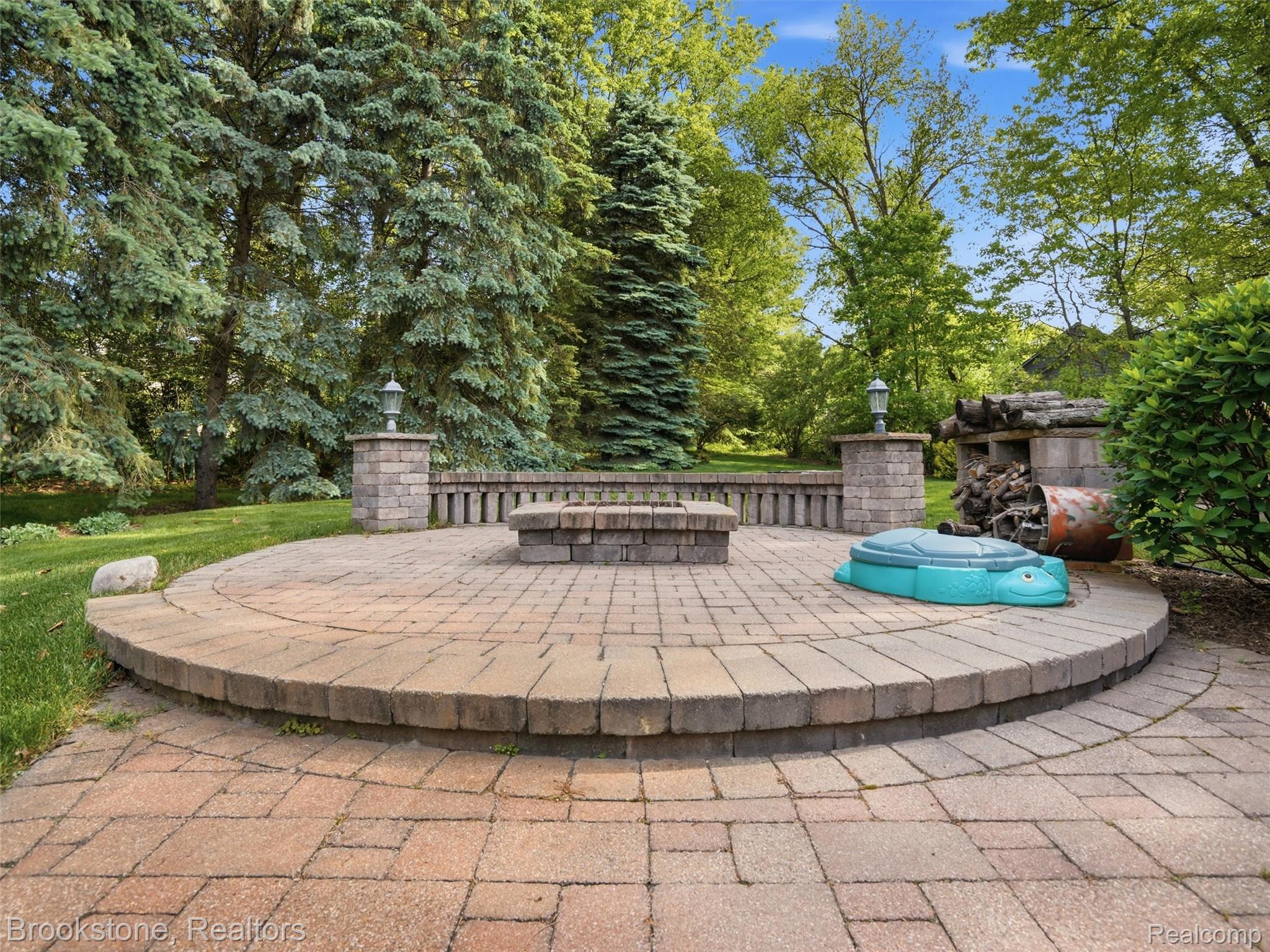 9523 Quail Ridge Run Brighton, MI 48114 - Photo 48 of 50 Expansive paver patio with a circular design and integrated fire pit