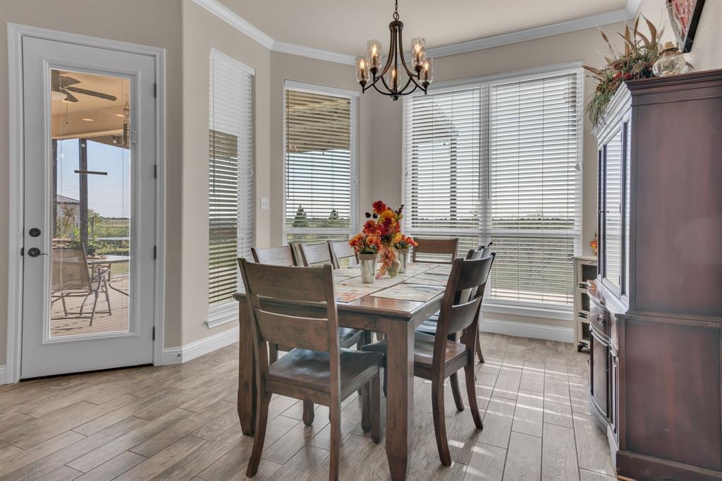 7728 County Road 1205 Rio Vista, TX 76093 - Photo 16 of 31 Dining area with crown molding, light wood-type flooring, and a chandelier
