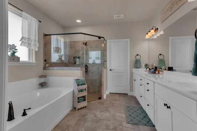 a spacious bathroom with a tub sink and mirror