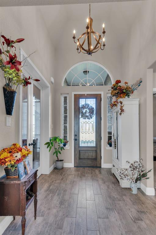 7728 County Road 1205 Rio Vista, TX 76093 - Photo 7 of 31 Entryway featuring a high ceiling, wood finished floors, french doors, and a chandelier
