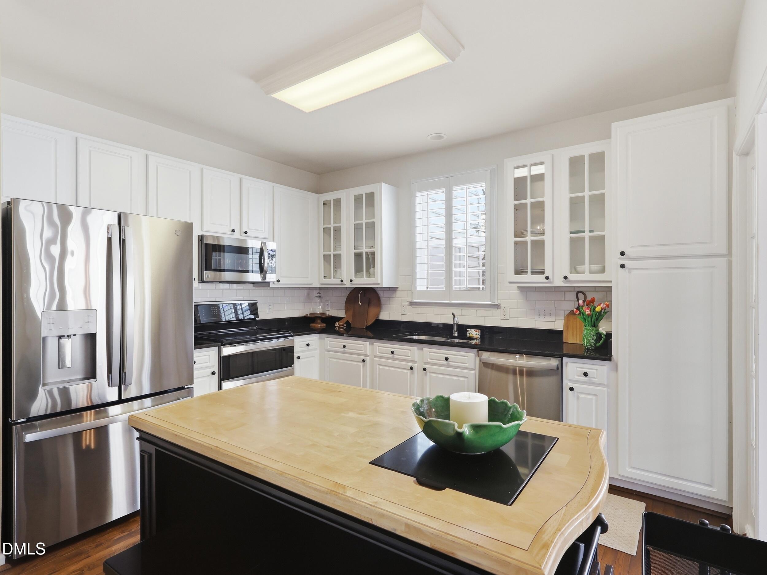 300 Nottinghill Walk Apex, NC 27502 - Photo 8 of 29 a kitchen with stainless steel appliances granite countertop a sink a stove and a refrigerator