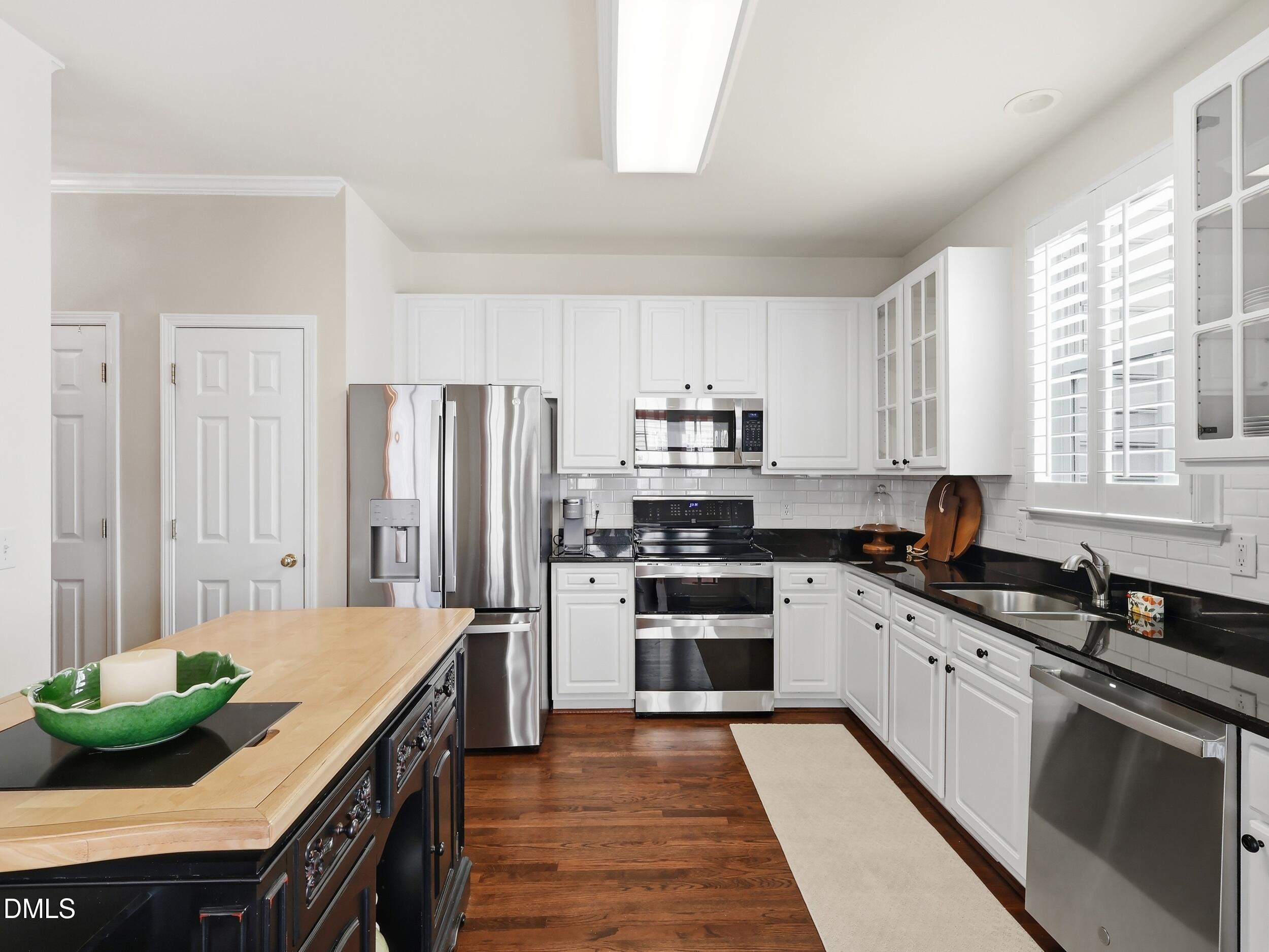 300 Nottinghill Walk Apex, NC 27502 - Photo 9 of 29 a kitchen with stainless steel appliances a stove sink and cabinets