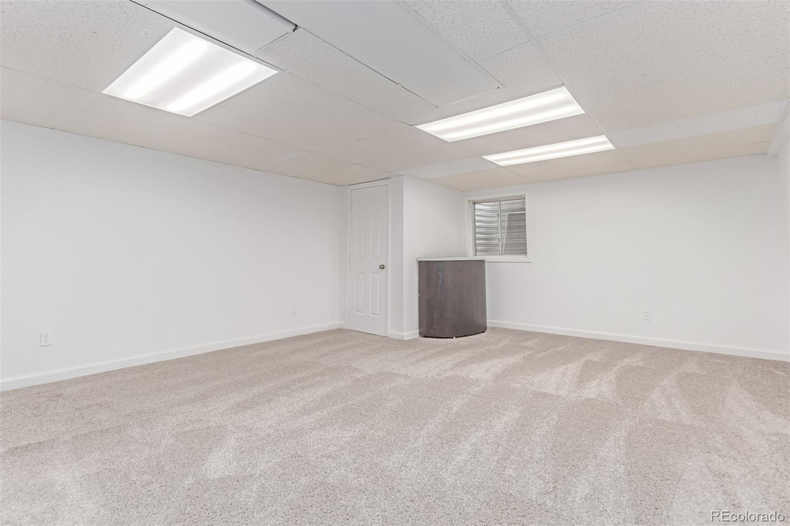 2675 South Deframe Circle Lakewood, CO 80228 - Photo 18 of 28 an empty room with windows and refrigerator in it