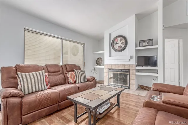 a living room with furniture a large window and a fireplace