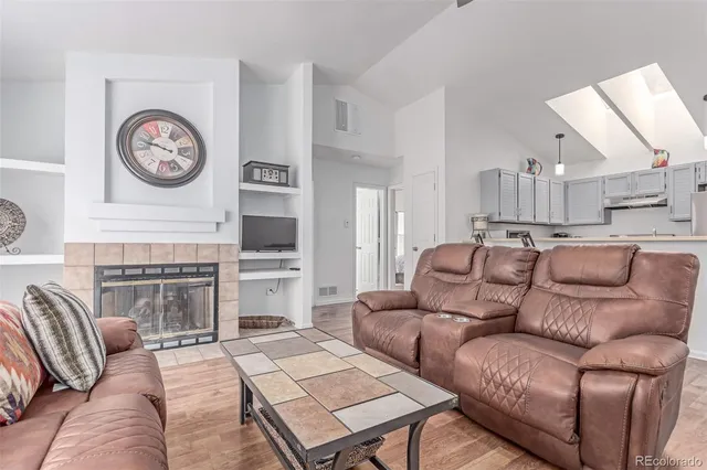 a living room with furniture a clock and a fireplace
