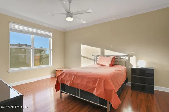 a bedroom with a bed and wooden floor