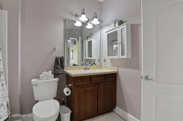 a bathroom with a toilet a sink and mirror