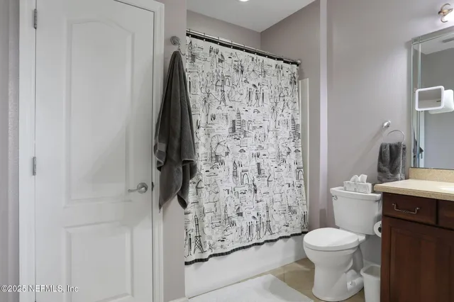 a bathroom with a toilet and a shower curtain