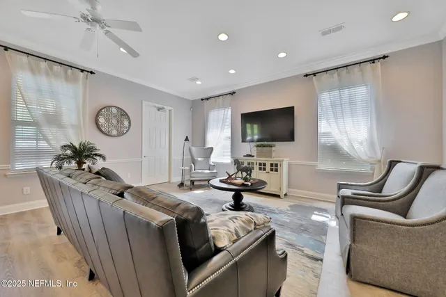 a living room with furniture a flat screen tv and a window