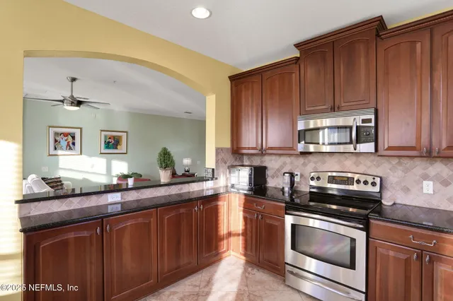 a kitchen with granite countertop stainless steel appliances a sink and cabinets