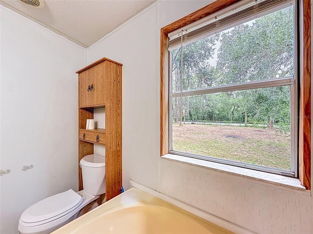 1819 Sinclair Hills Road Lutz, FL 33549 - Photo 36 of 60 a bathroom with a toilet sink and a shower
