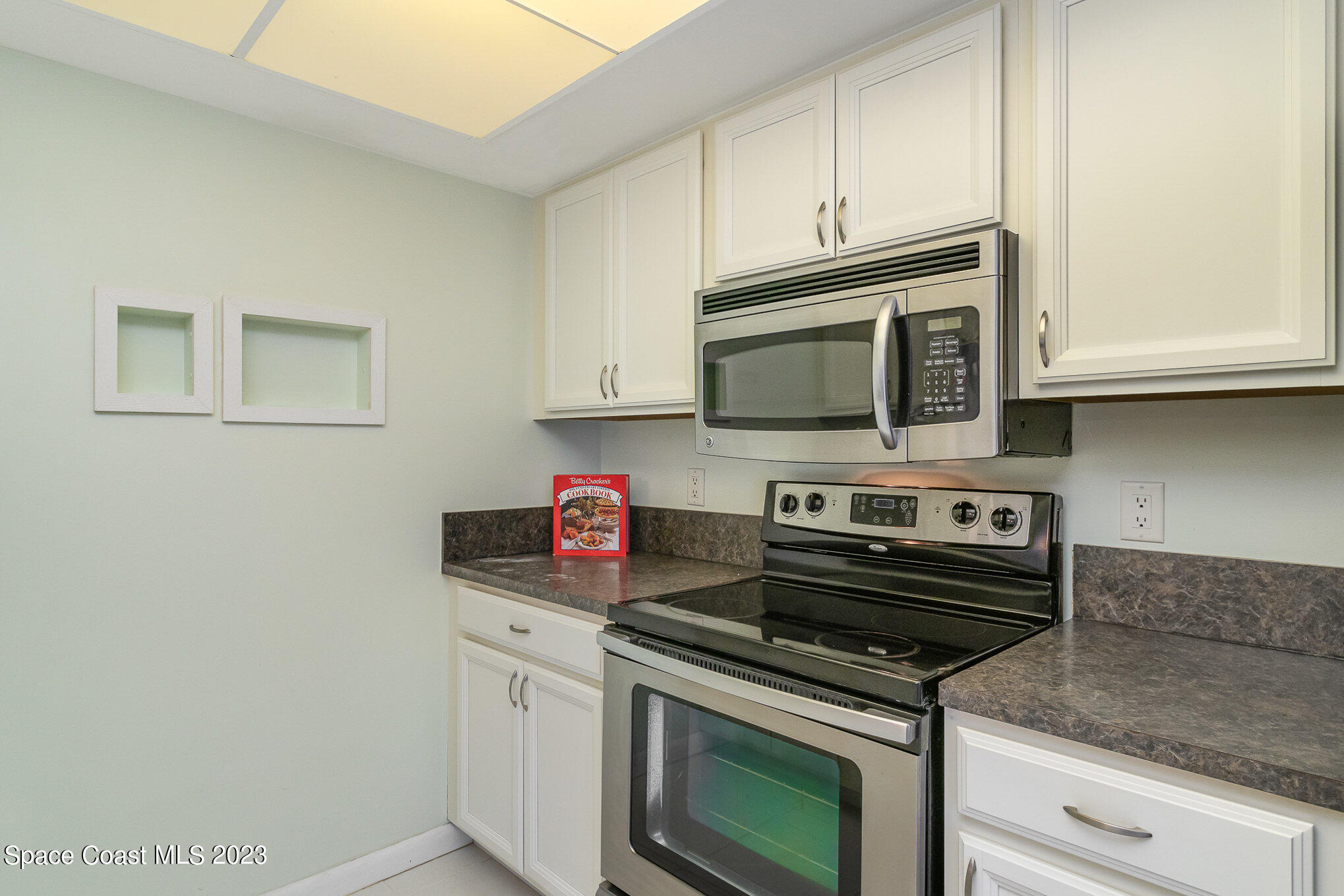 756 Ridge Club Drive, Unit 61 Melbourne, FL 32934 - Photo 12 of 29 a kitchen with stainless steel appliances granite countertop a stove a microwave and cabinets
