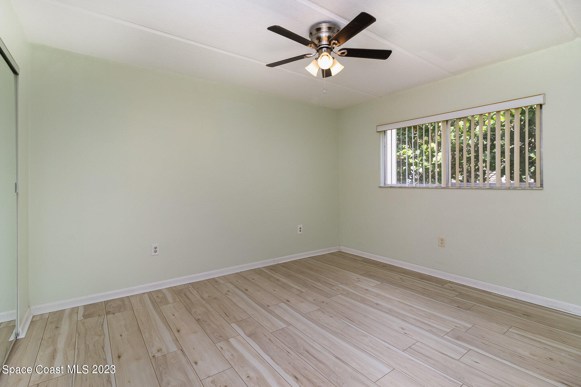 756 Ridge Club Drive, Unit 61 Melbourne, FL 32934 - Photo 16 of 29 wooden floor in an empty room with a window