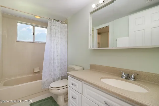 an empty room with a window and a ceiling fan