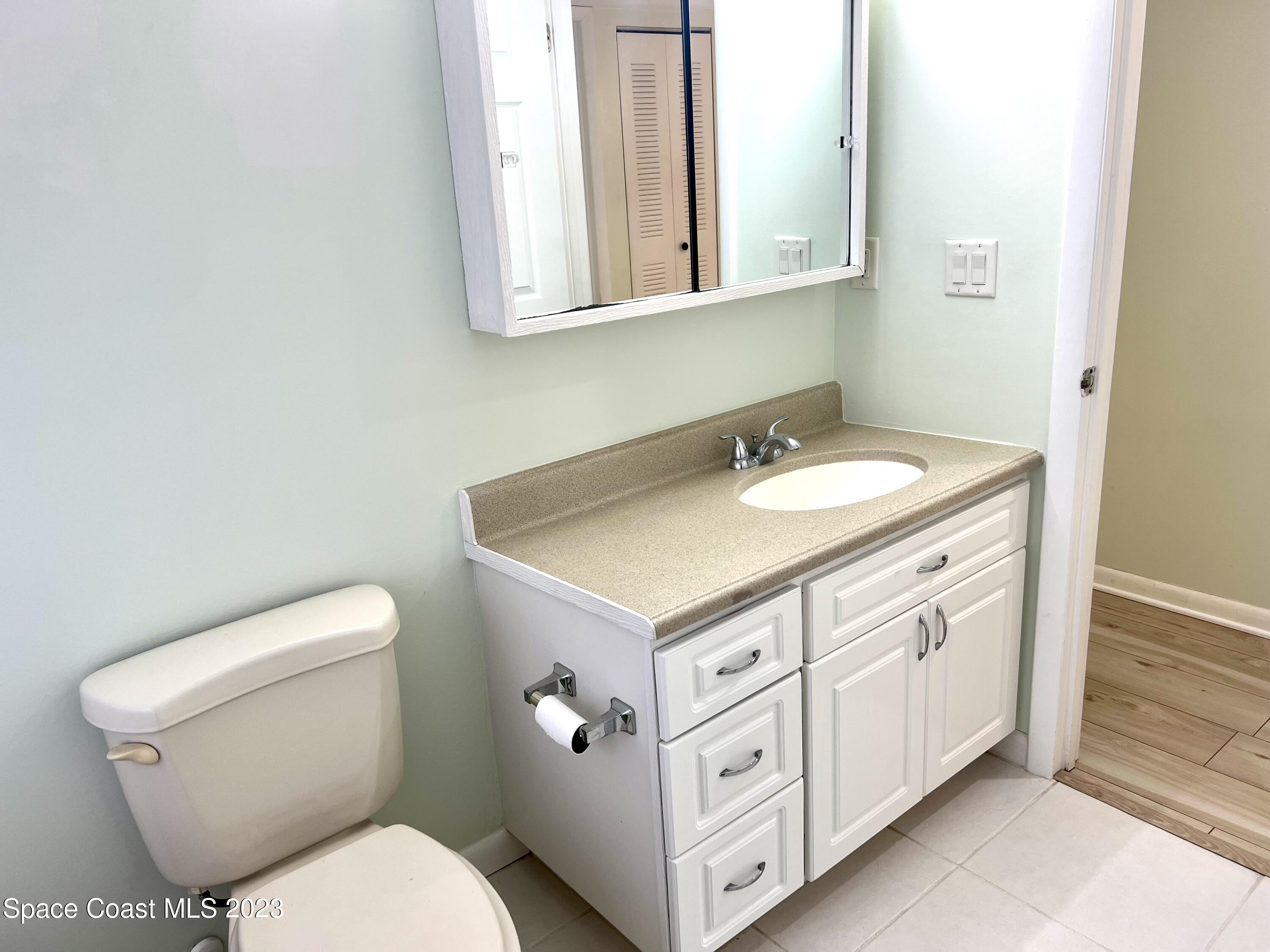 756 Ridge Club Drive, Unit 61 Melbourne, FL 32934 - Photo 20 of 29 a bathroom with a toilet sink and mirror