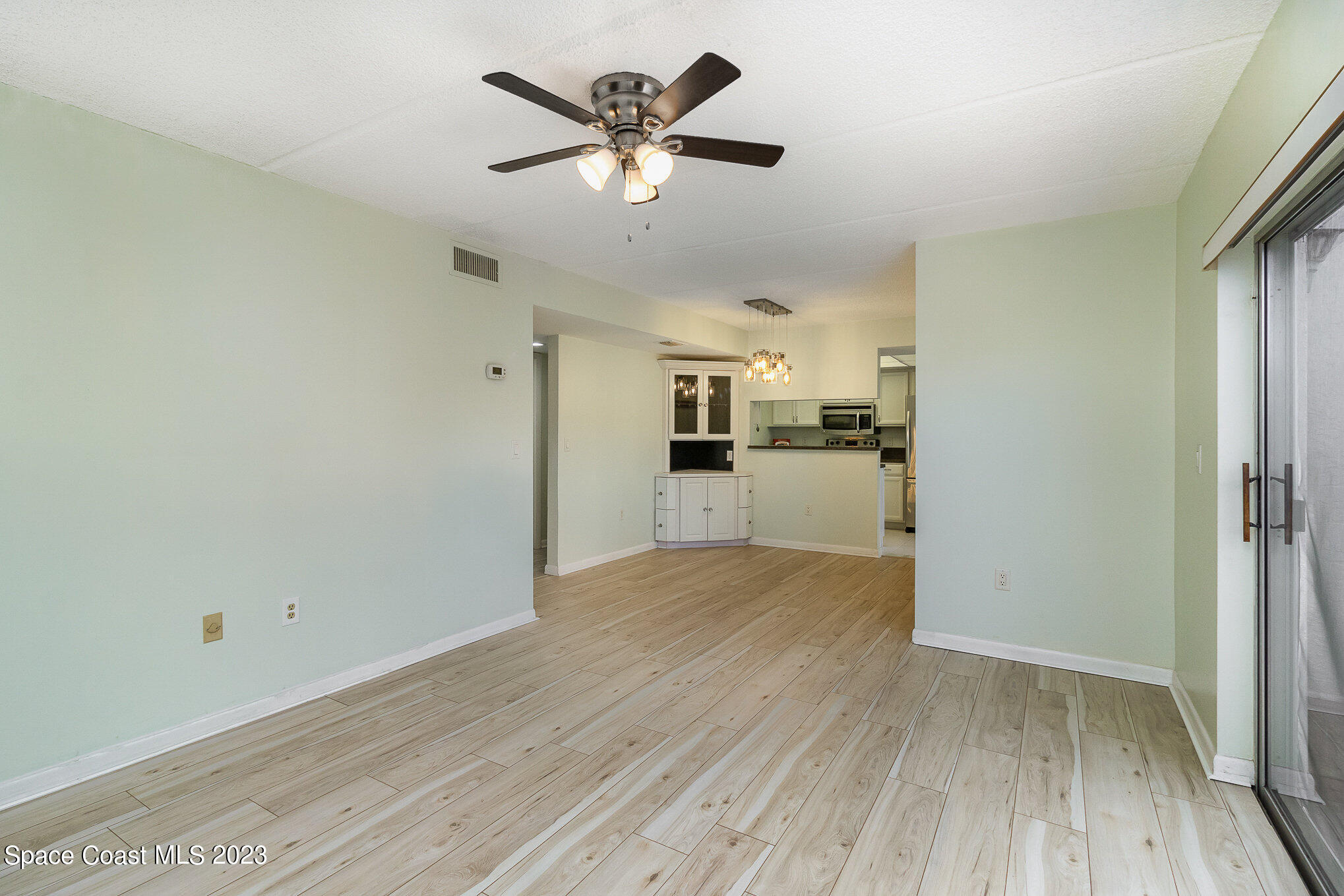 756 Ridge Club Drive, Unit 61 Melbourne, FL 32934 - Photo 7 of 29 a view of a kitchen with wooden floor and a ceiling fan