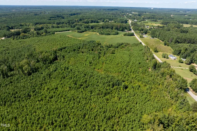 an aerial view of residential houses with outdoor space and trees