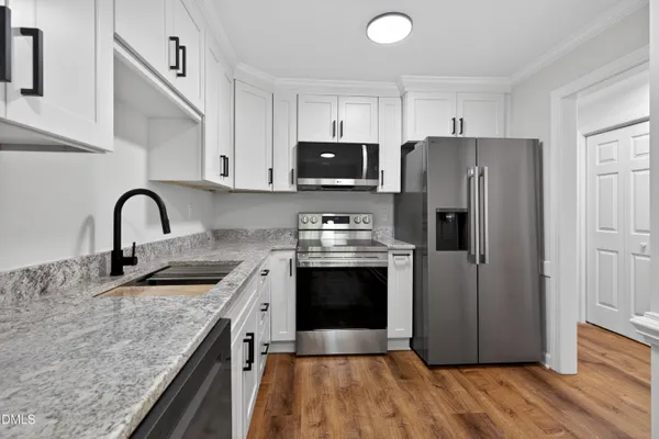 a kitchen with stainless steel appliances granite countertop a stove a sink and a refrigerator