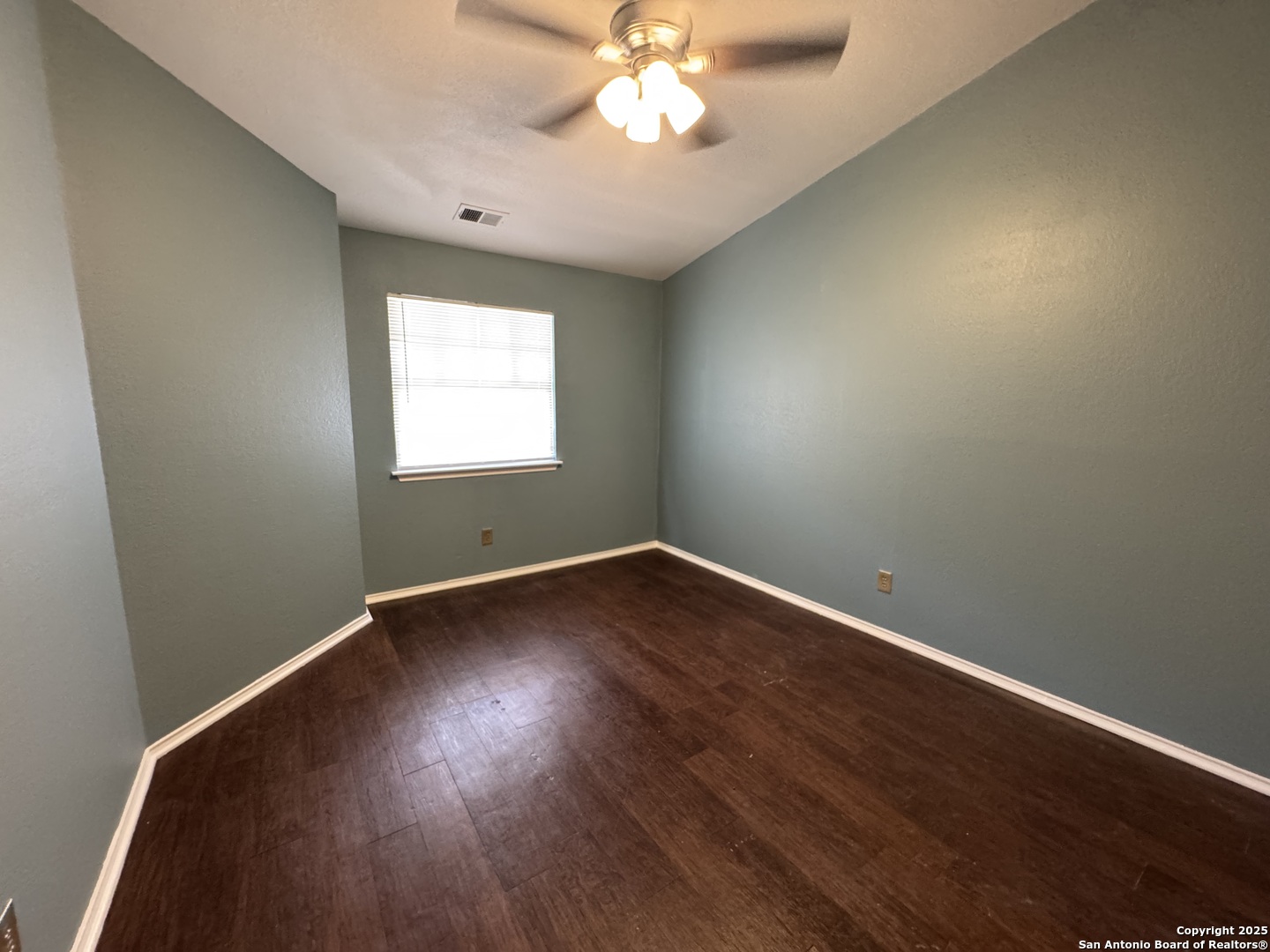 4803 Hamilton Wolfe Road, Unit 606 San Antonio, TX 78229 - Photo 7 of 9 an empty room with wooden floor and windows