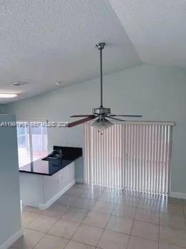 14218 Southwest 176th Terrace Miami, FL 33177 - Photo 13 of 19 a kitchen with kitchen island white cabinets and black appliances