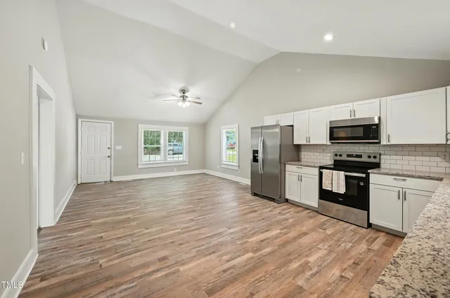 a view of a kitchen with a sink stove top oven and refrigerator