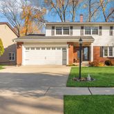 a front view of a house with a garden and plants